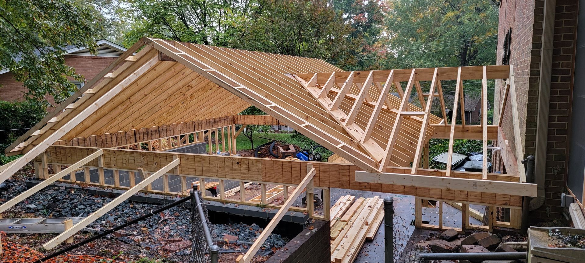 A wooden structure is being built on top of a house.