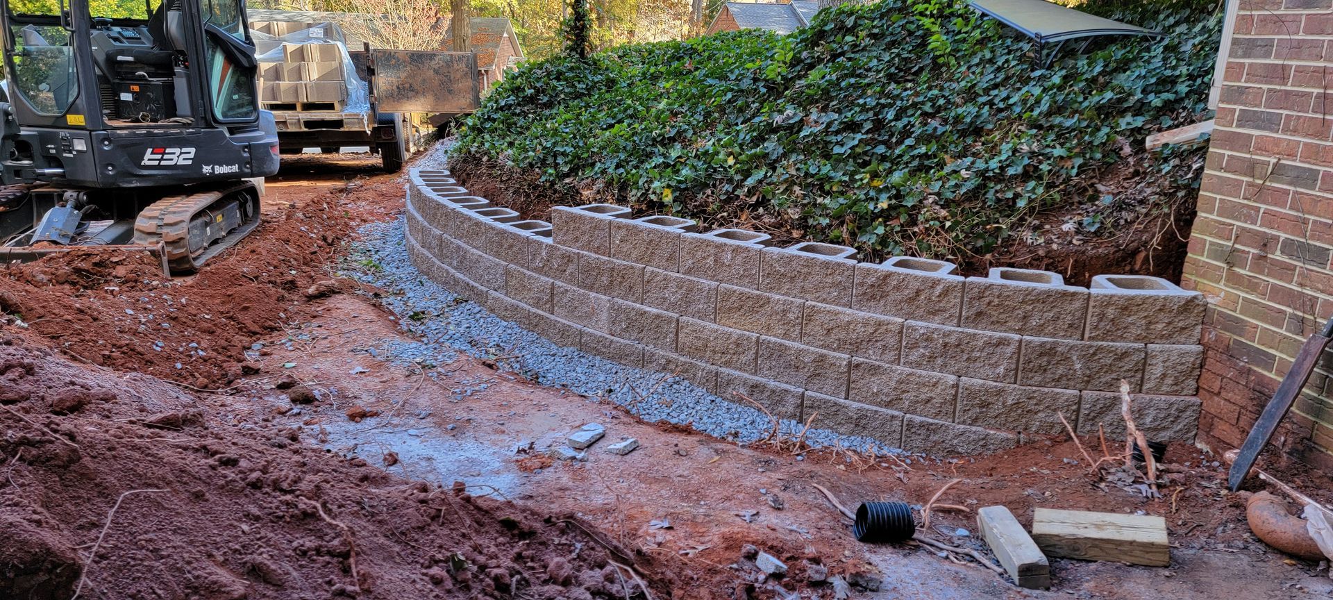 A brick wall is being built in front of a house.