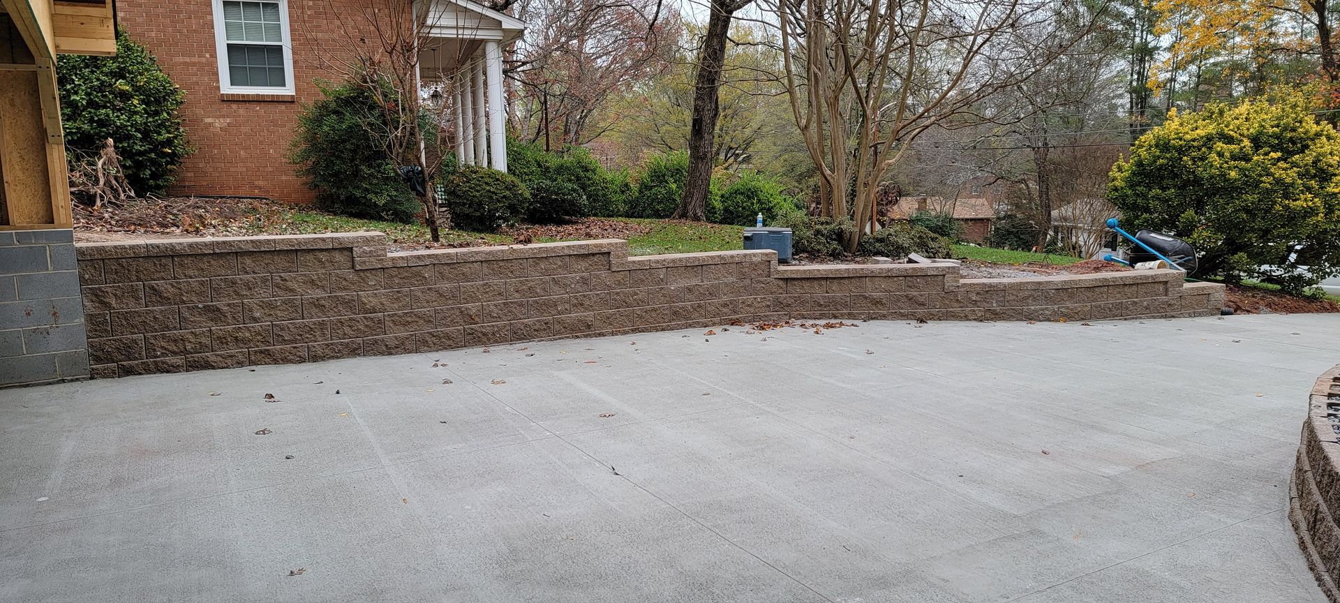 A brick wall is being built in the driveway of a house.
