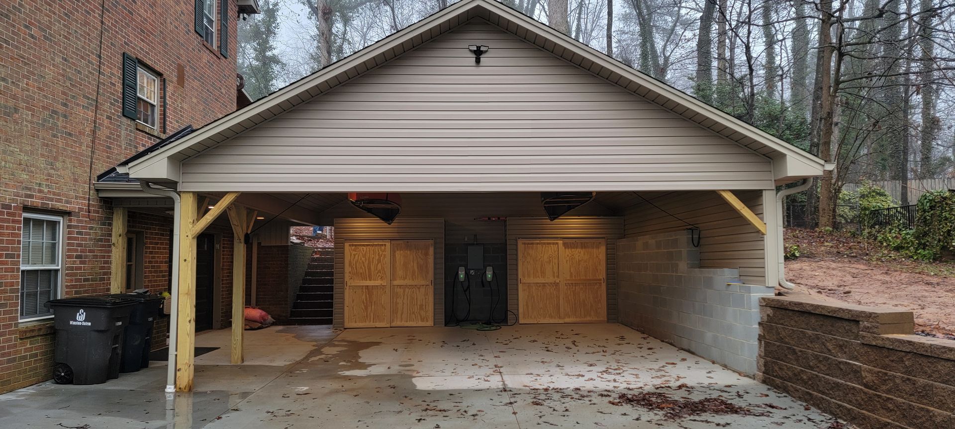 A garage with a canopy over it and a brick building in the background.