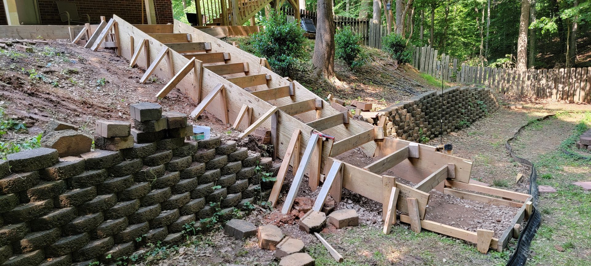 A wooden staircase is being built on top of a brick wall.
