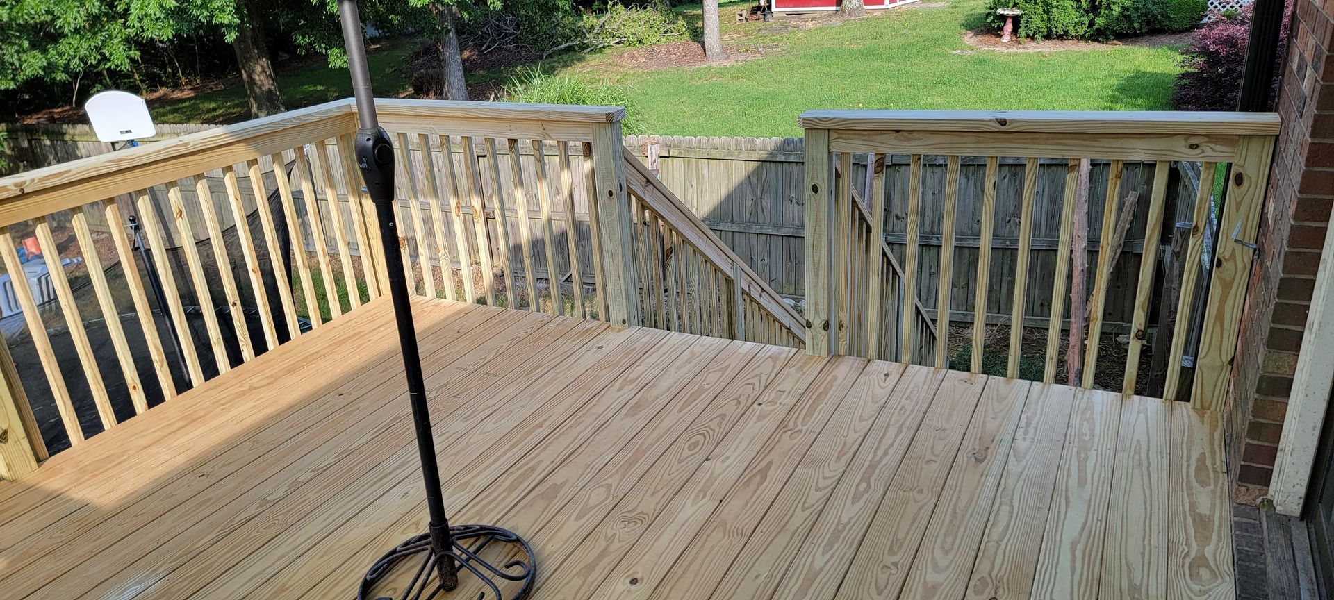 A wooden deck with stairs and an umbrella on it.