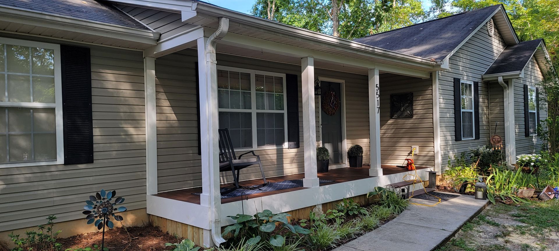 A house with a porch and a walkway leading to it.