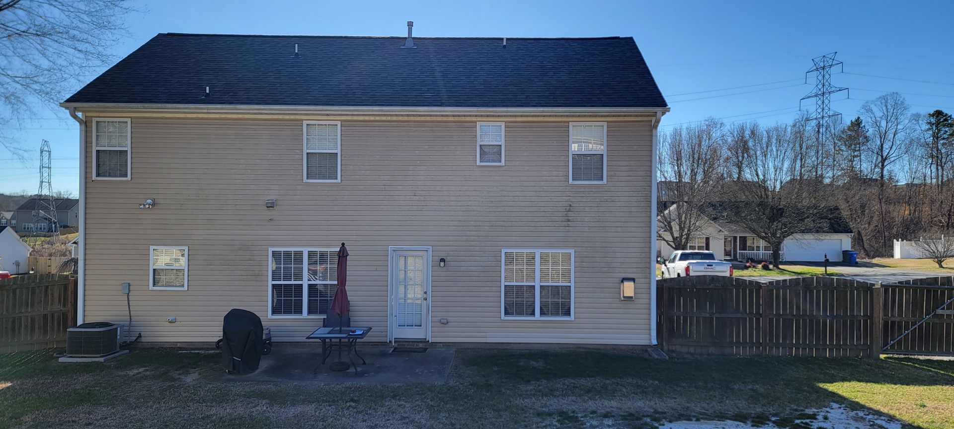 The back of a house with a fence and a lot of windows.