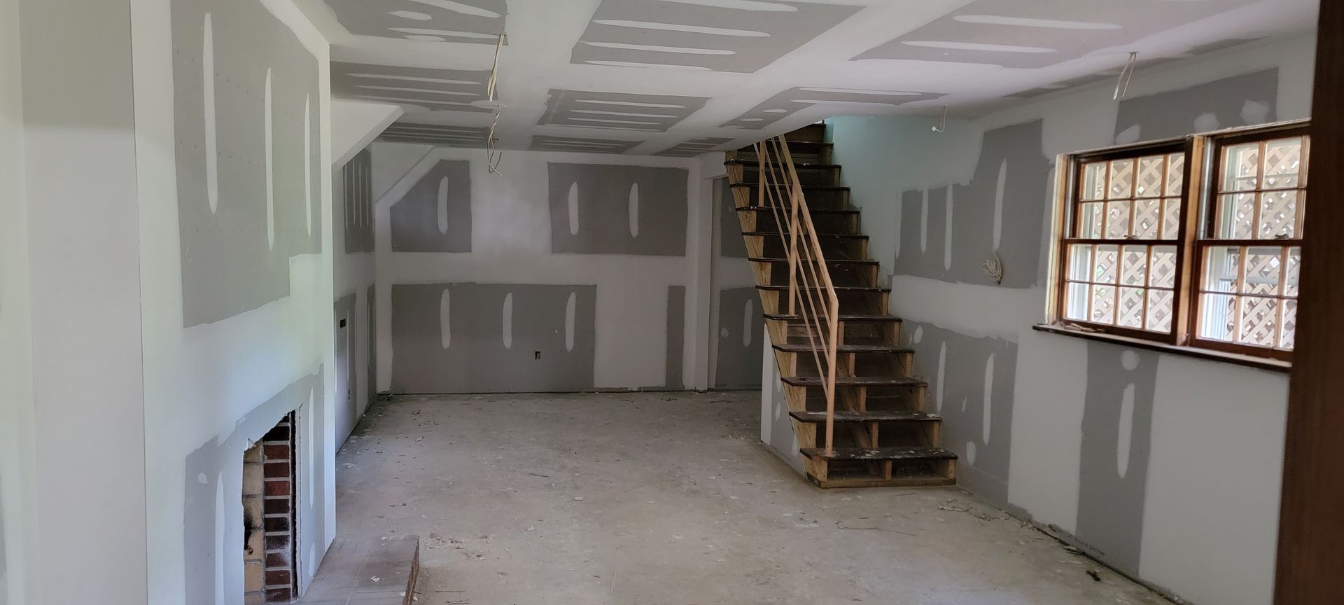 An empty room with a staircase going up to the second floor.