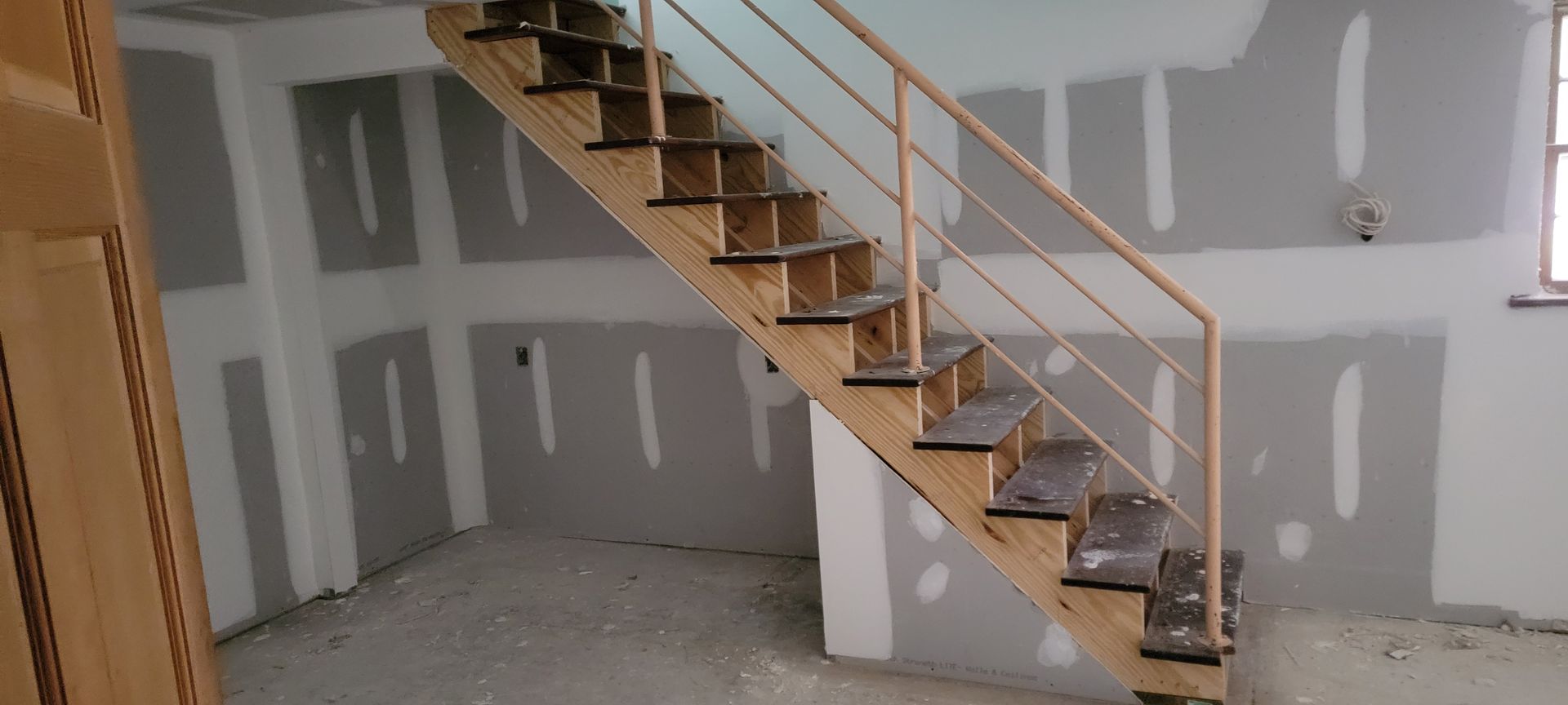 A wooden staircase in a room with a metal railing.