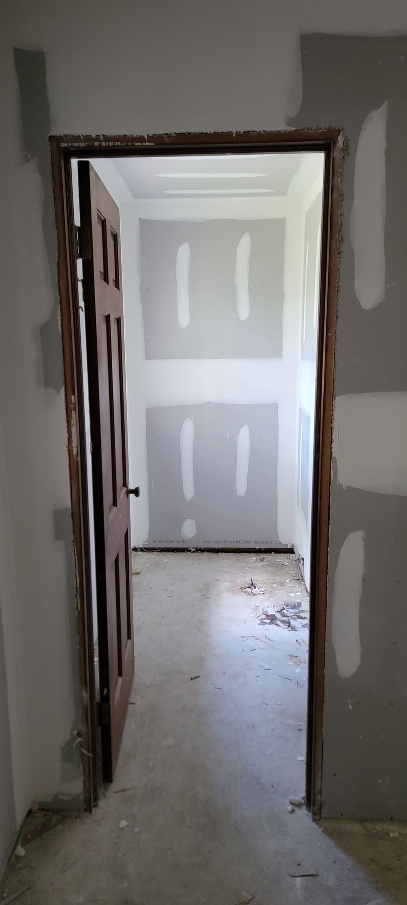 A door is open in a room with drywall on the walls.