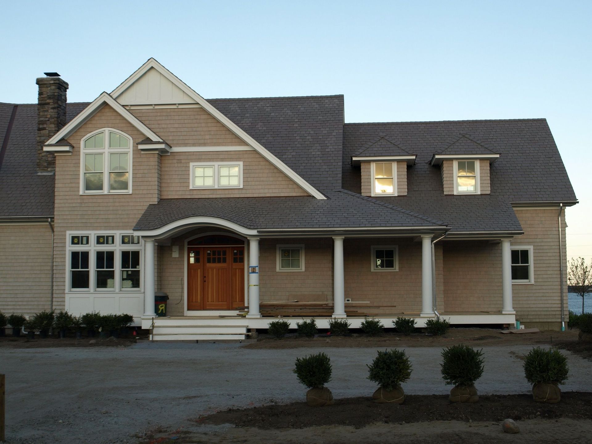 A large house with a porch and a gray roof