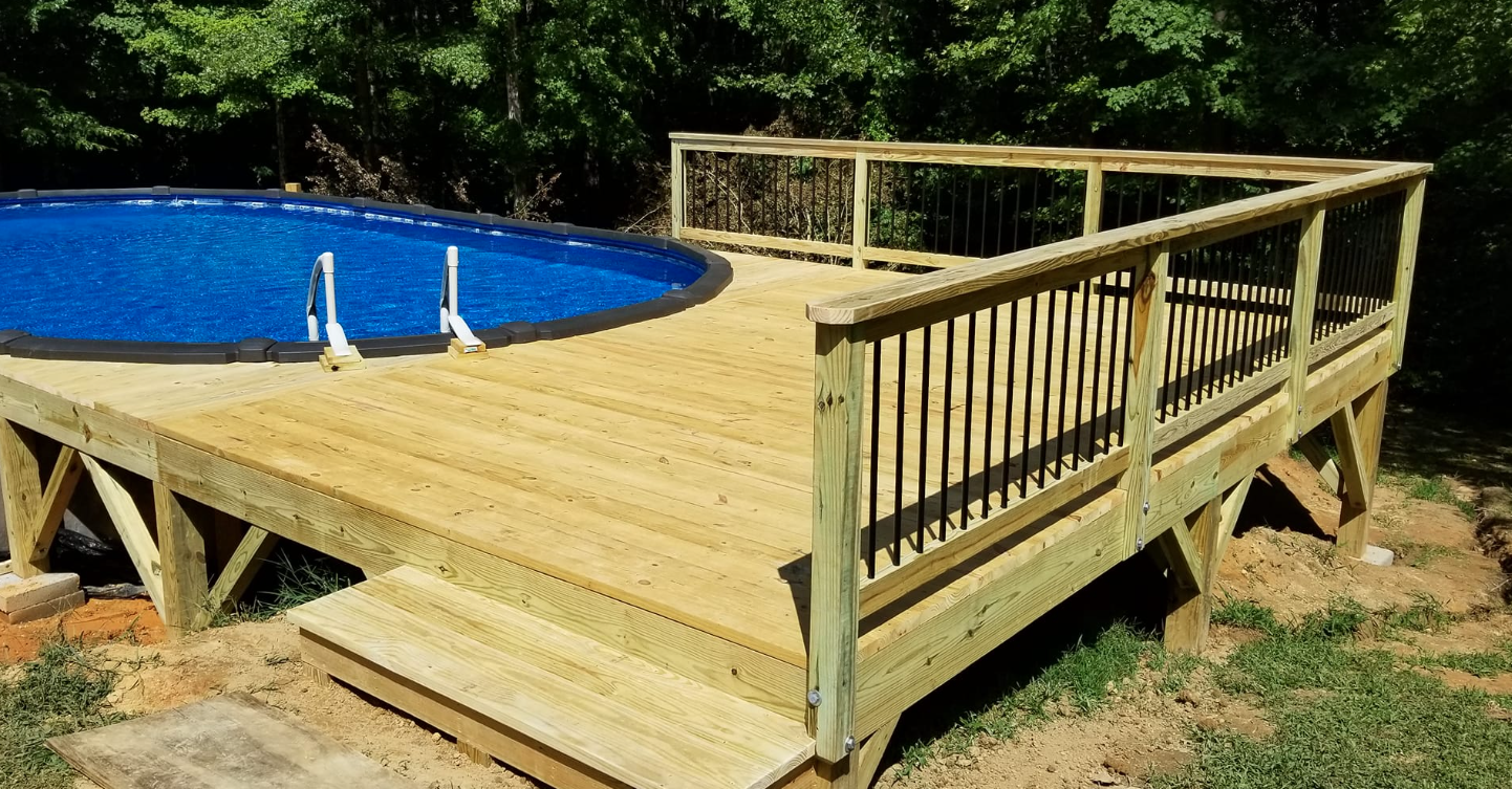 A wooden deck with a swimming pool in the background.