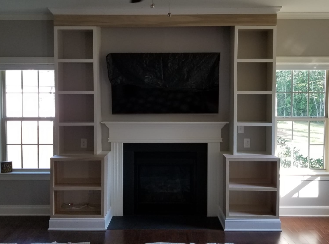 A living room with a fireplace and a flat screen tv