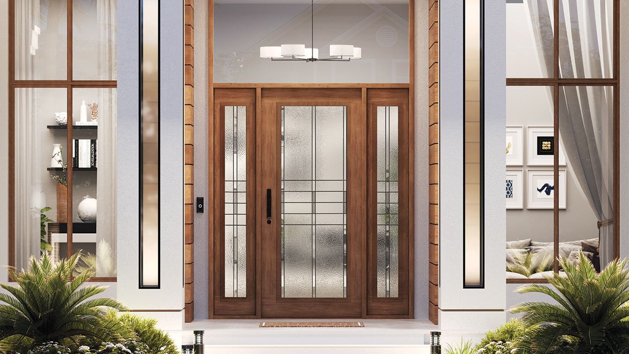 A wooden front door with sidelights, framed by white pillars, a chandelier, and landscaping. The door has textured glass and a black handle.