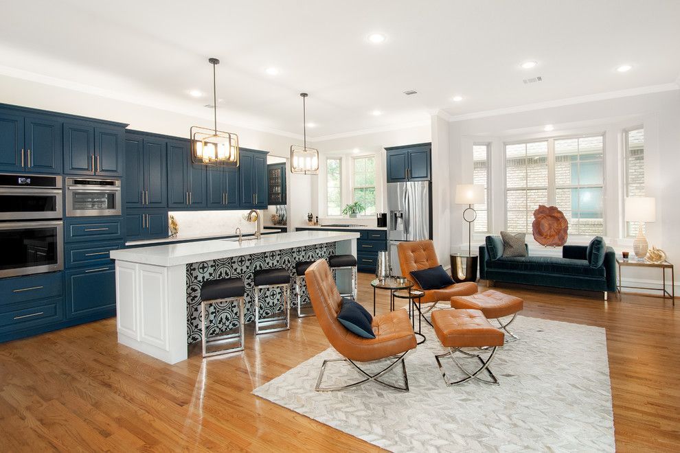 A living room filled with furniture and a kitchen with blue cabinets.