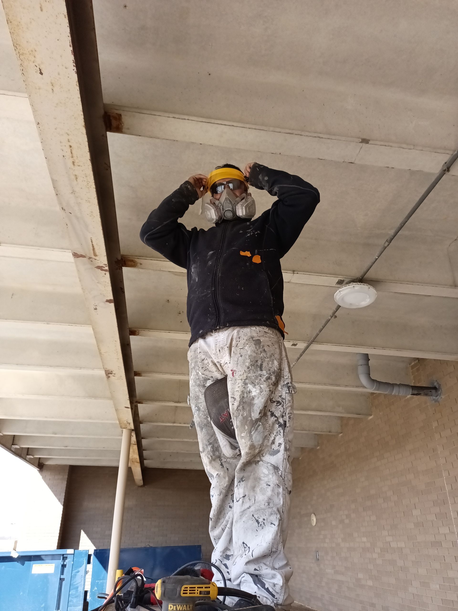 Painter in safety gear prepping for industrial painting services