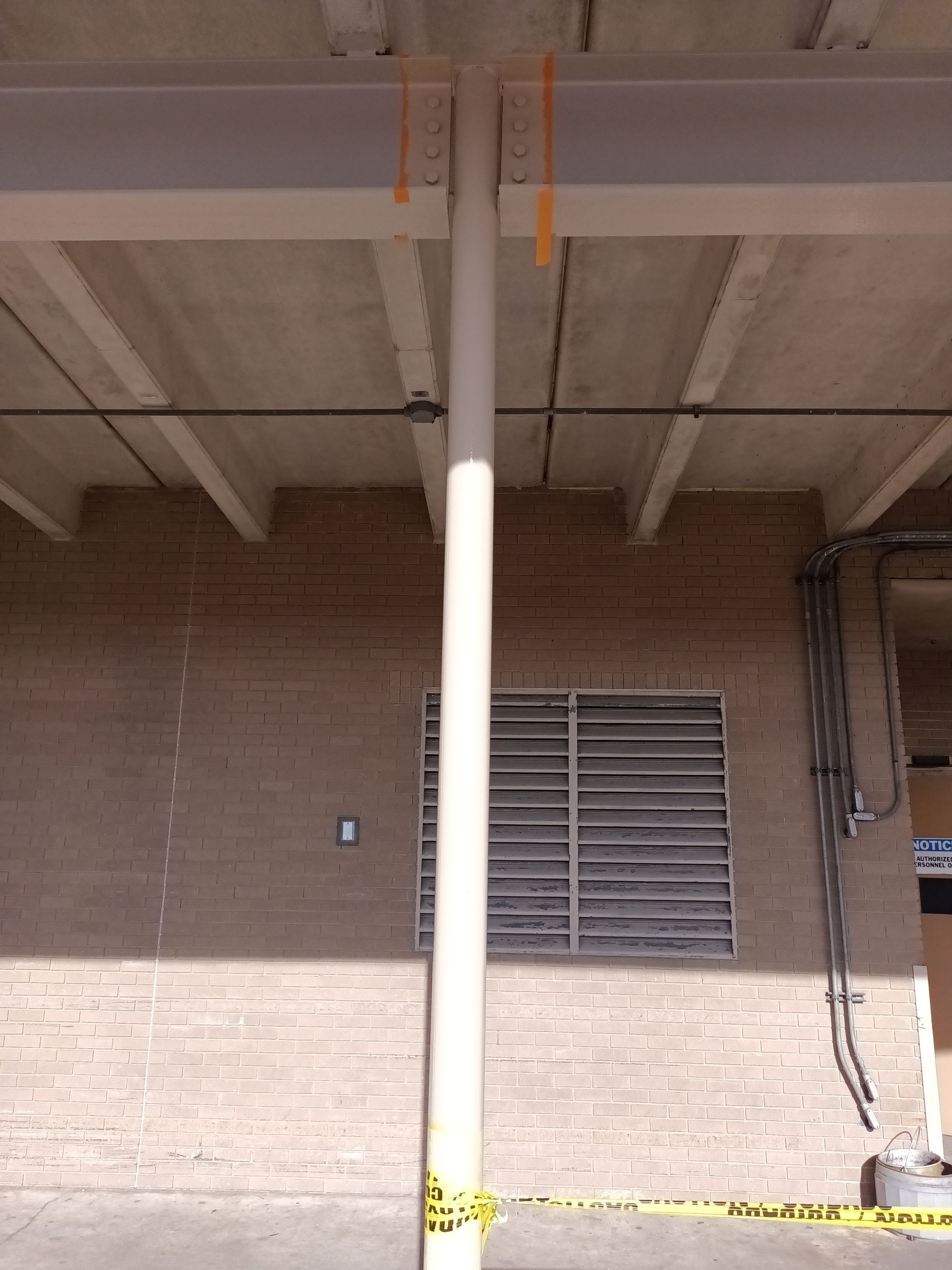 A brick building with a white pole in front of it