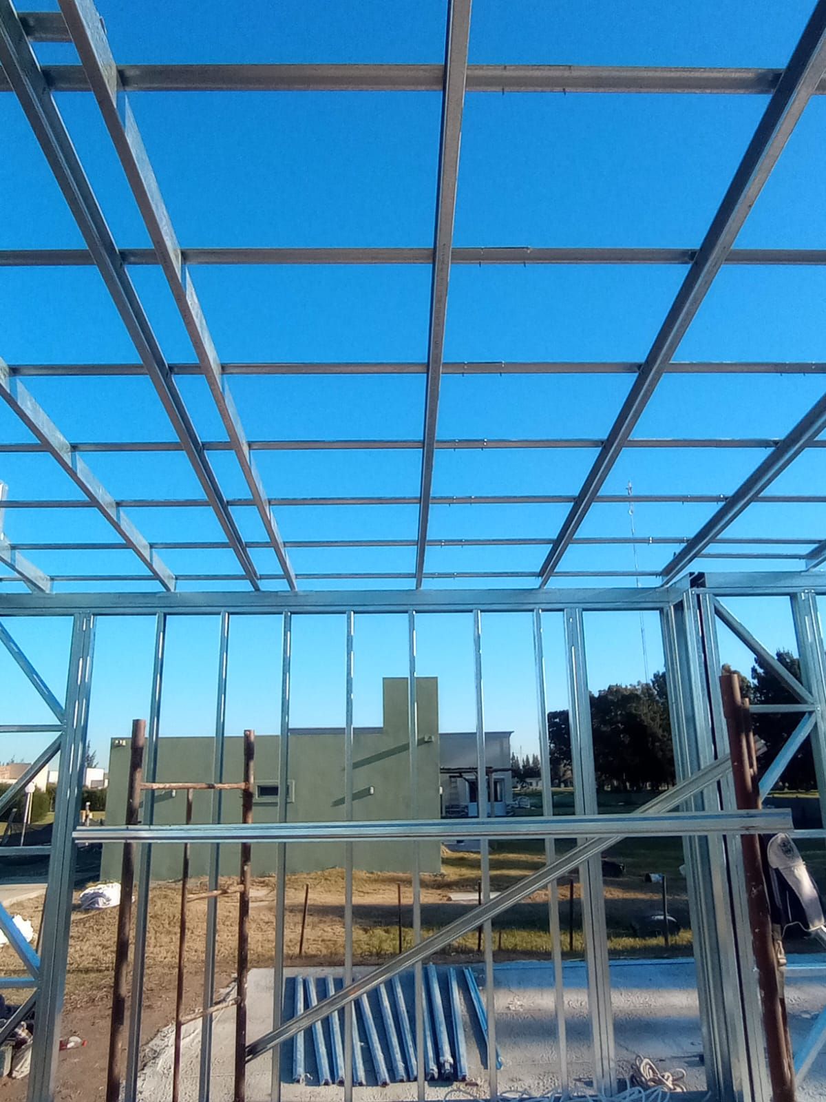 Estructura de acero en construcción bajo un cielo azul brillante.