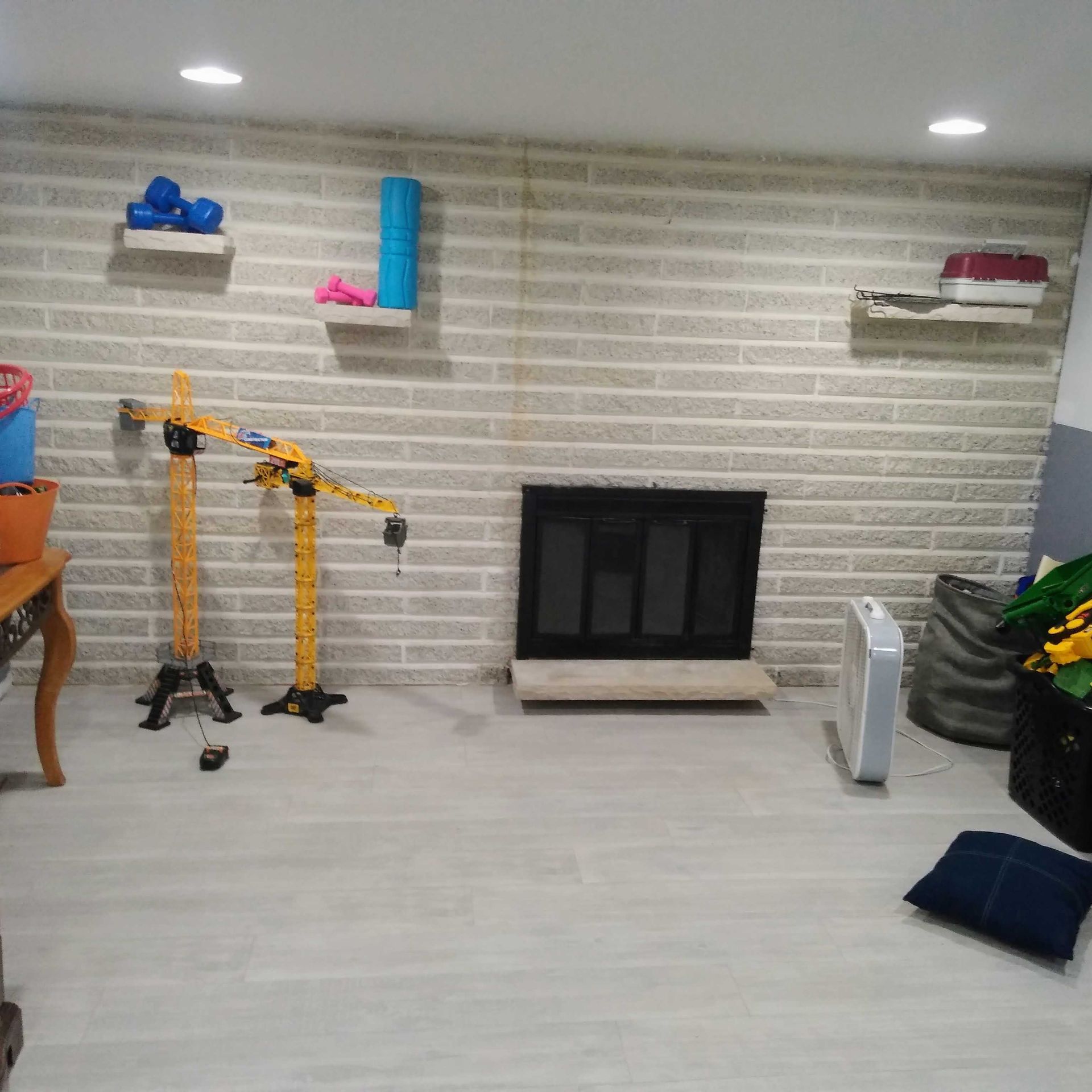 A living room with a brick wall and a fireplace