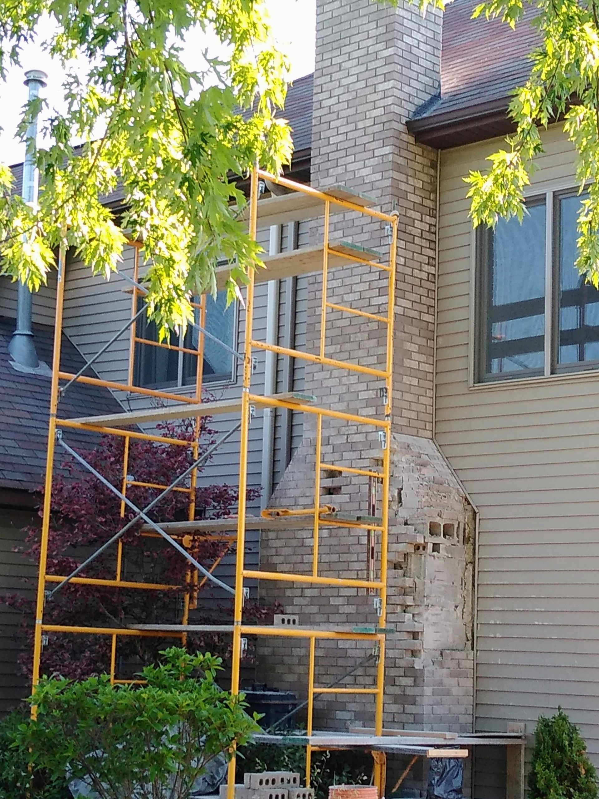 A yellow scaffolding is sitting in front of a house