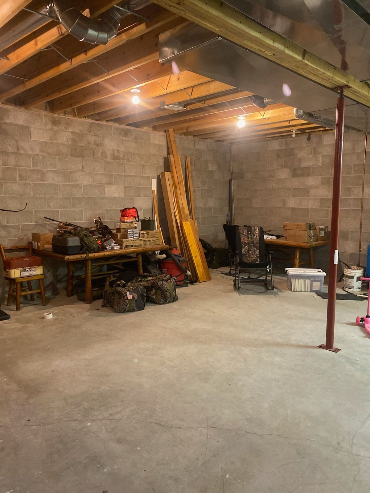 A basement filled with lots of junk and a table.