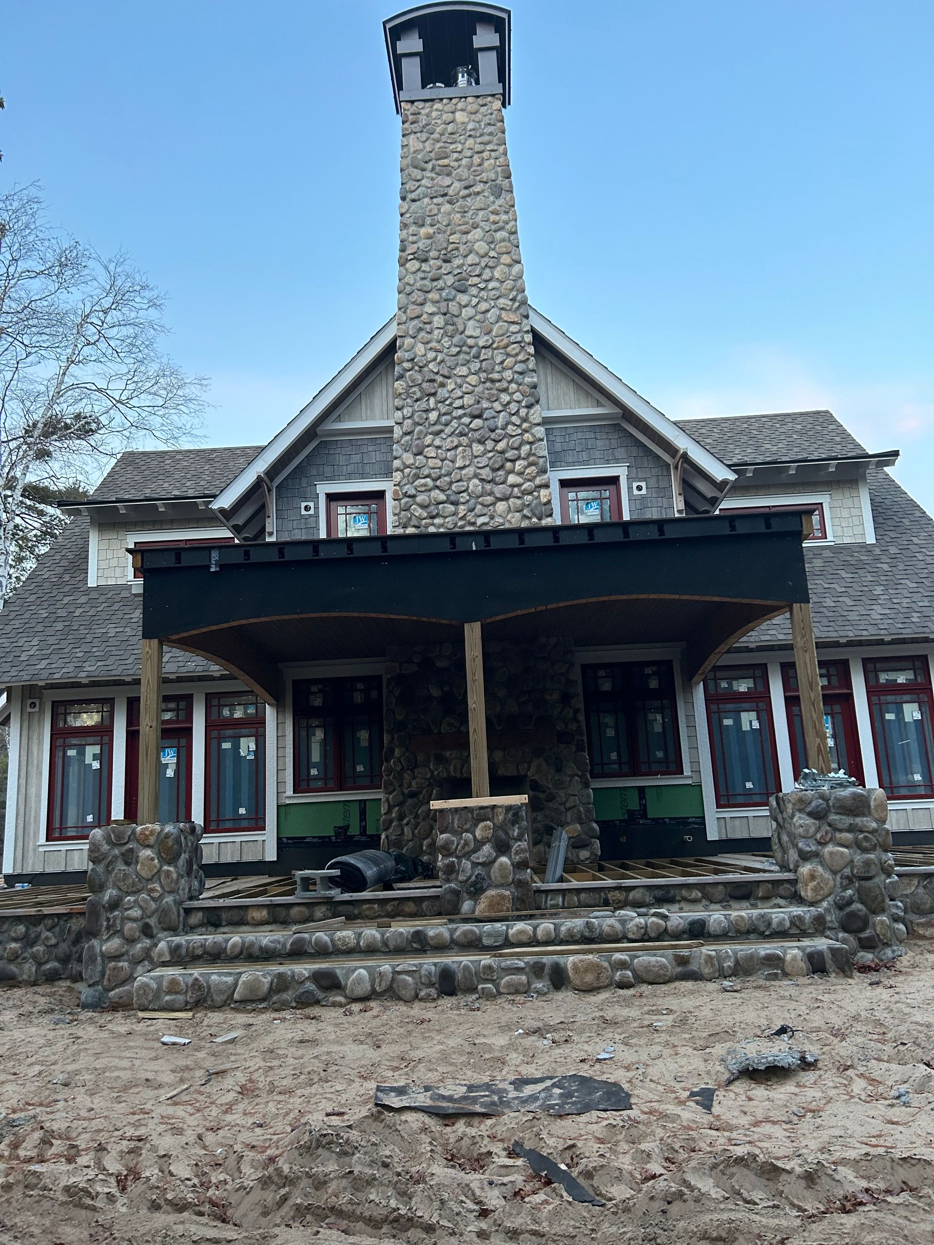 A large house with a stone chimney on top of it.