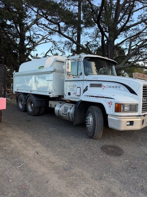 Irrigation system spraying water on a green field under a cloudy sky.