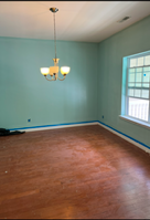 An empty room with a chandelier hanging from the ceiling