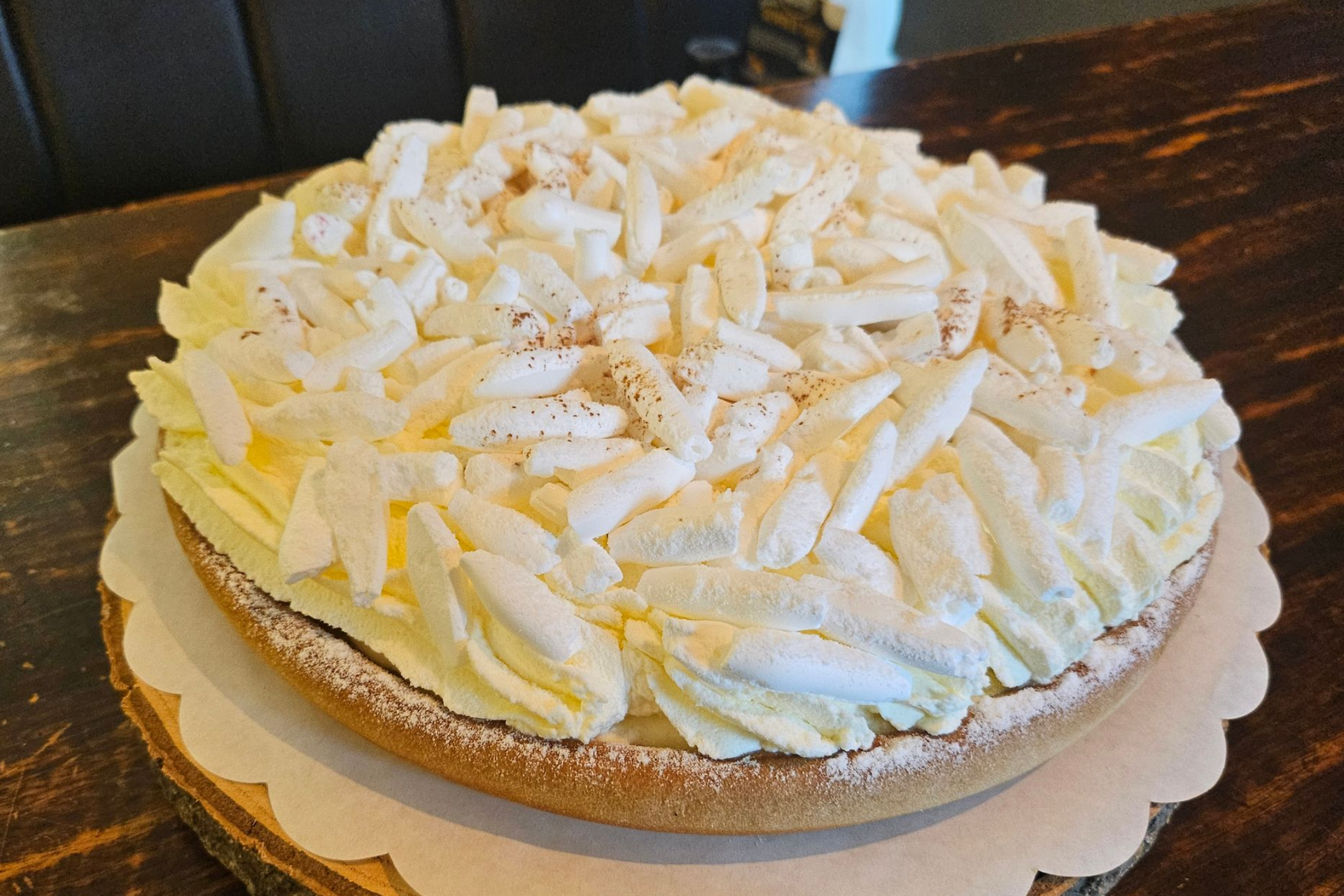 Een ronde taart, bedekt met witte room en stukjes schuim.