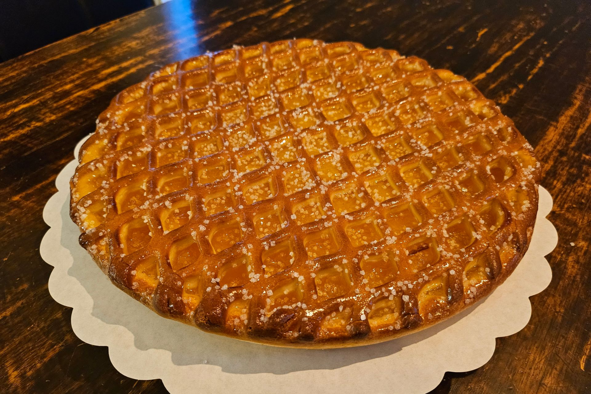 Een goudbruine taart met een rasterpatroon op de bovenkant met abrikozen.