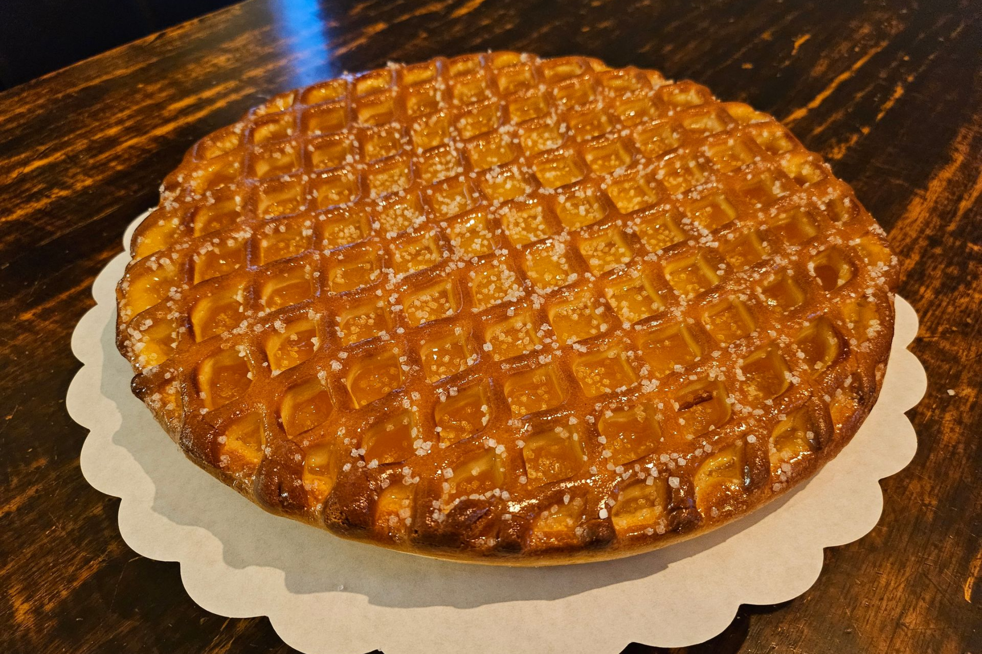 Een goudbruine taart met een rasterpatroon op de bovenkant met abrikozen.