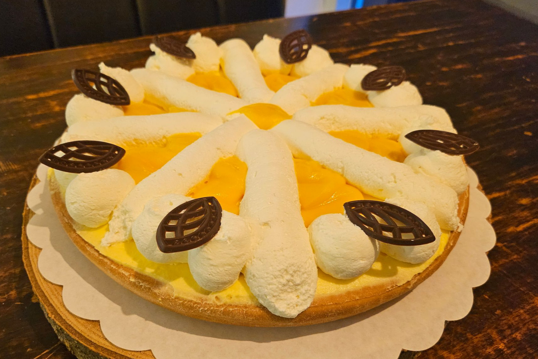 Een advocaattaart, versierd met slagroompatronen en decoratieve chocoladeblaadjes.