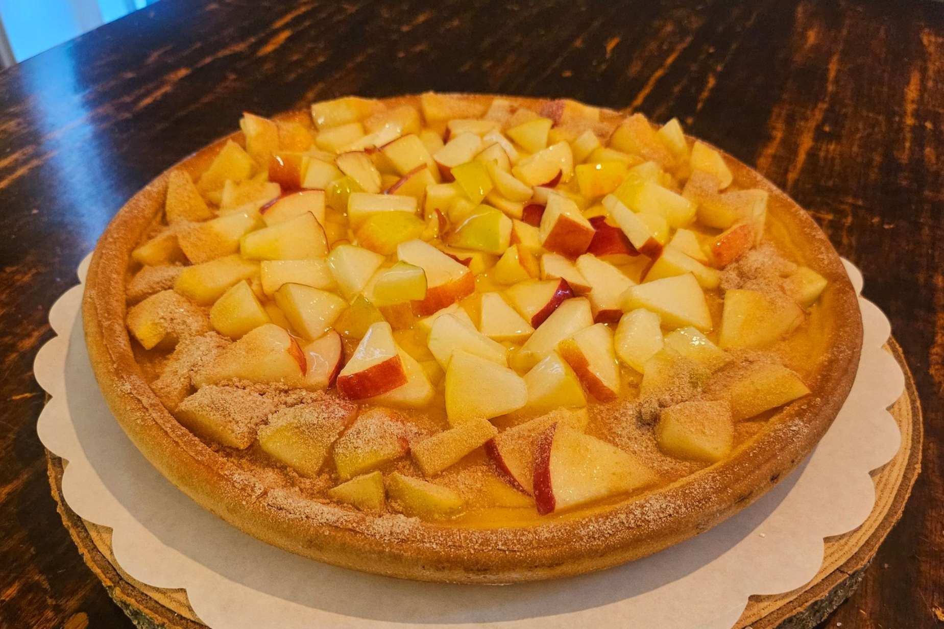 Een ronde appeltaart met blokjes fruit als topping.