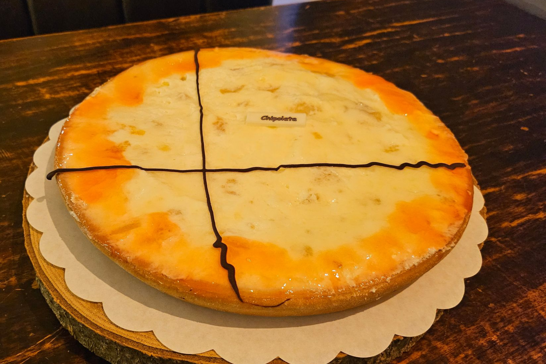 Een ronde taart met slagroom, vruchten, rum en bitterkoekjes.