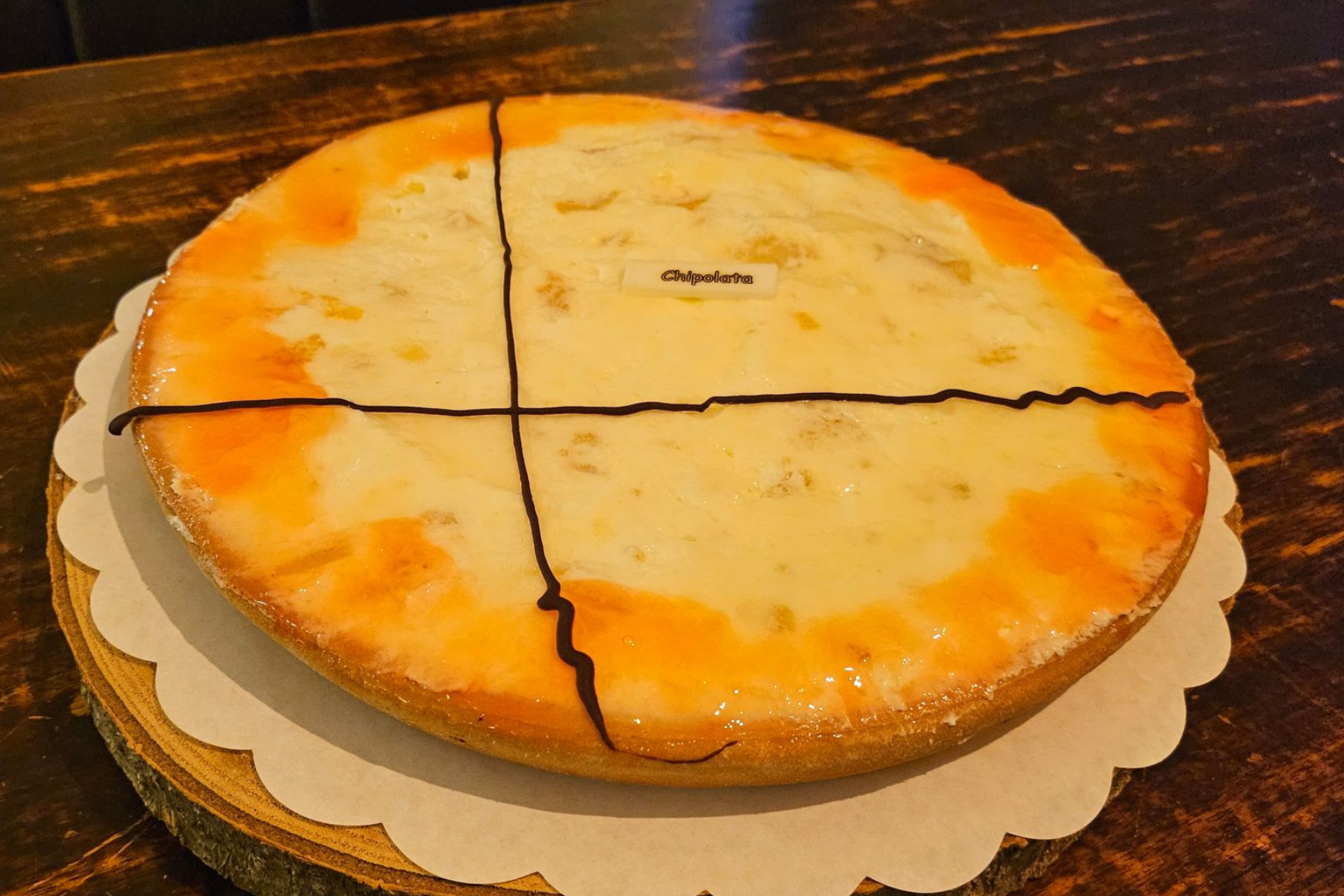 Een ronde taart met slagroom, vruchten, rum en bitterkoekjes.