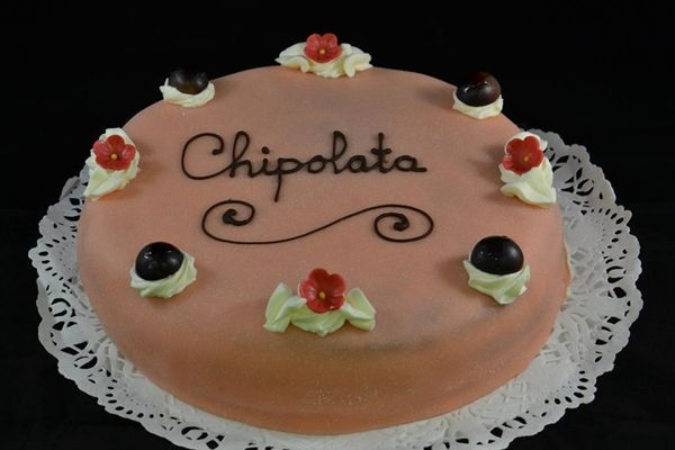 Een ronde, lichtoranje taart met het opschrift 