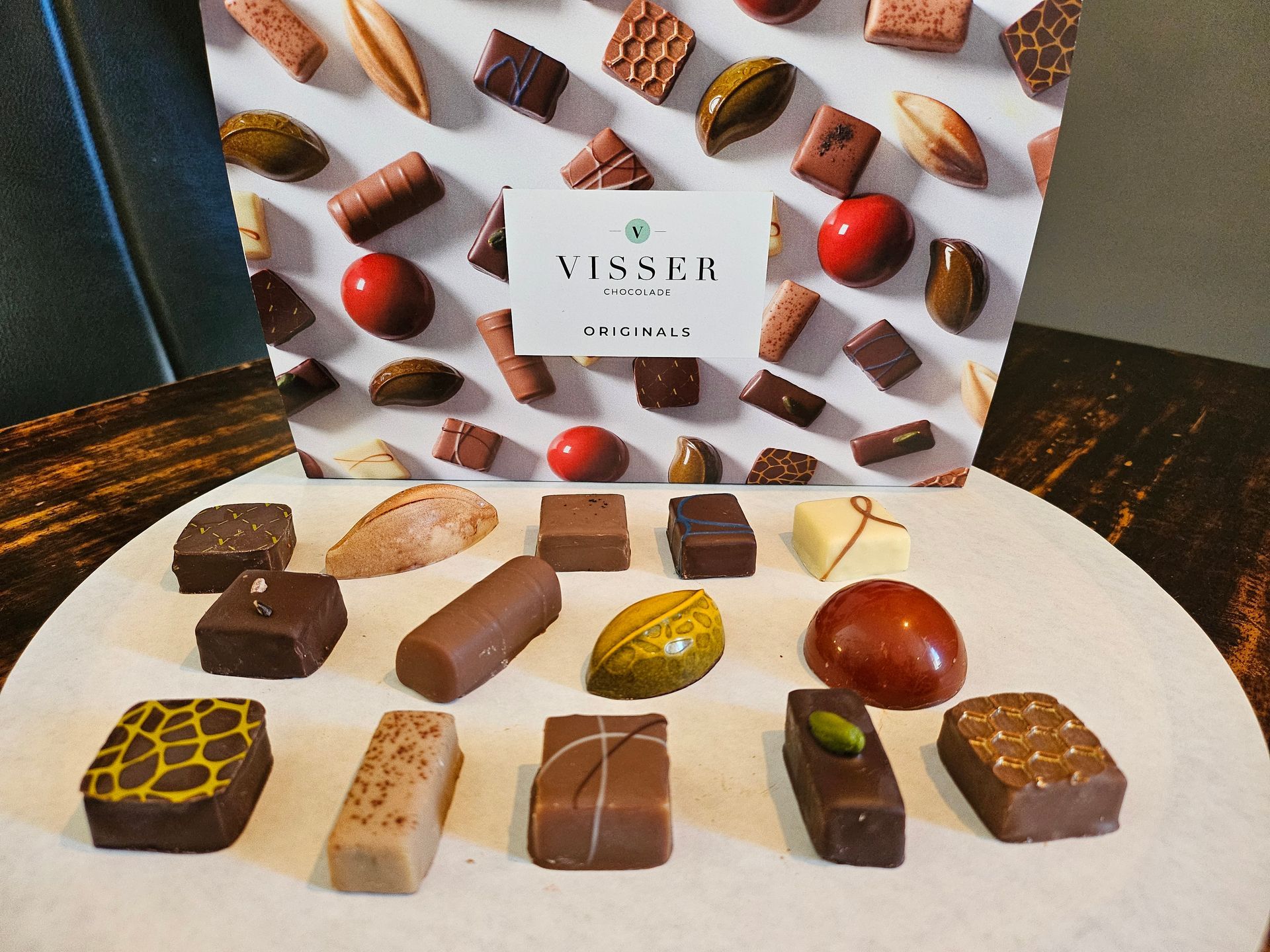 Een assortiment chocolaatjes met een Visser-doos op de achtergrond.