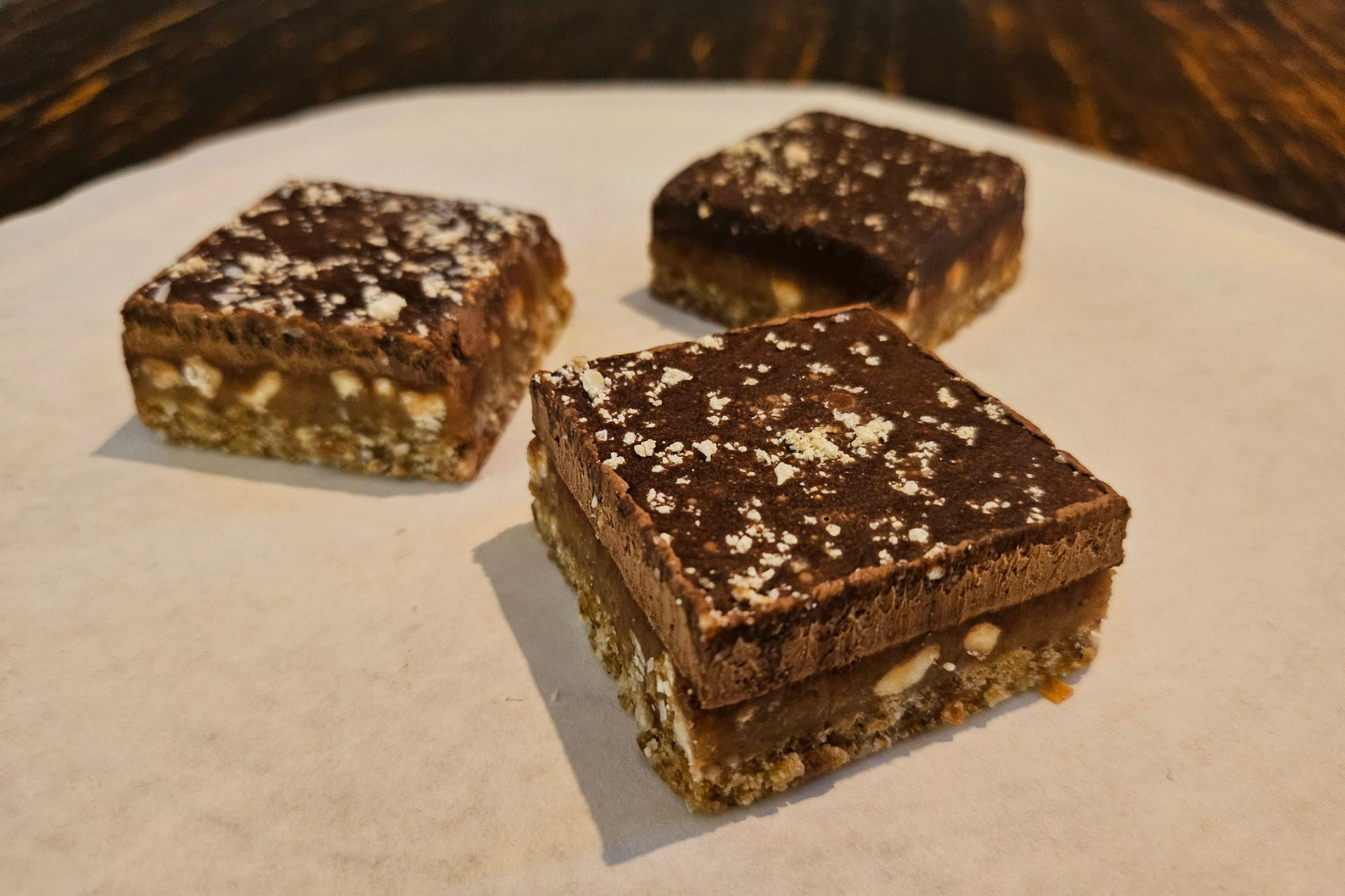 Drie vierkante repen met chocolade, karamel en noten.