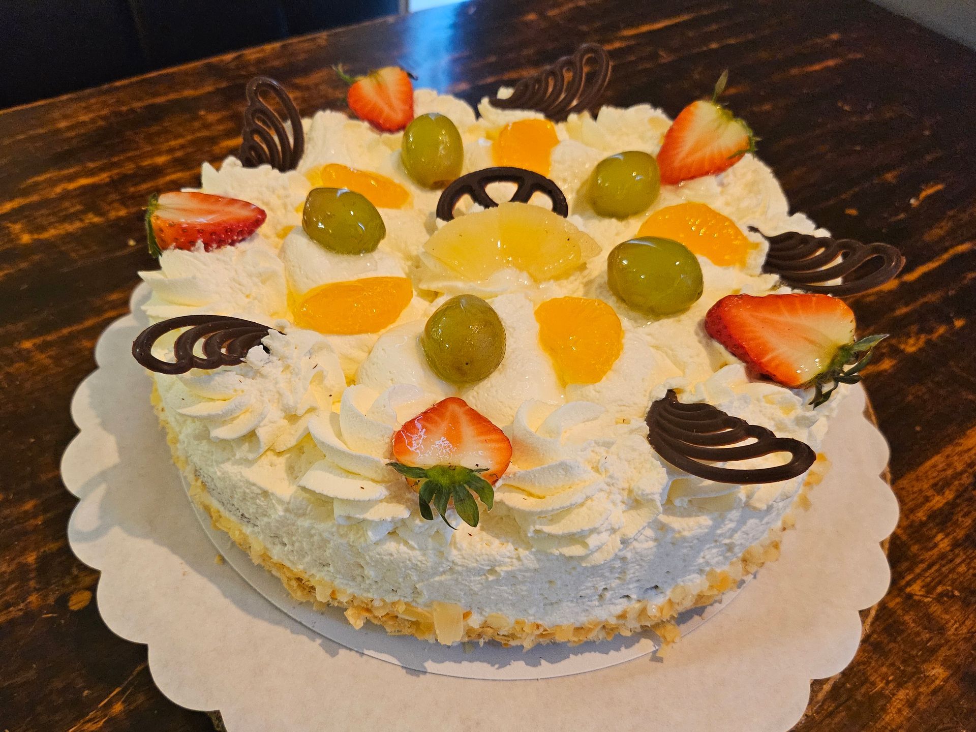 Versierde taart met fruit en slagroom.