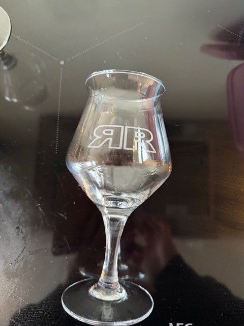 Een helder wijnglas op voet met een spiegelend 