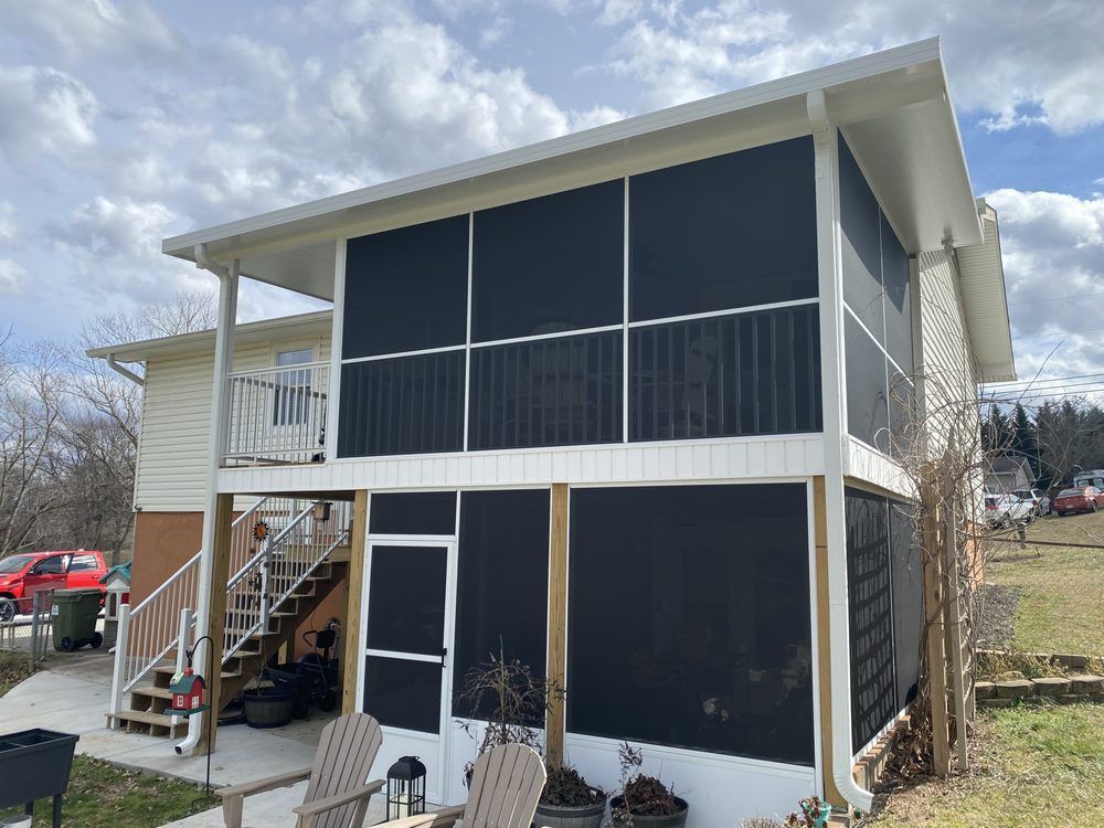 A white house with a screened in porch and stairs.