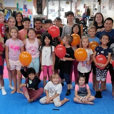 A group of children are posing for a picture with balloons