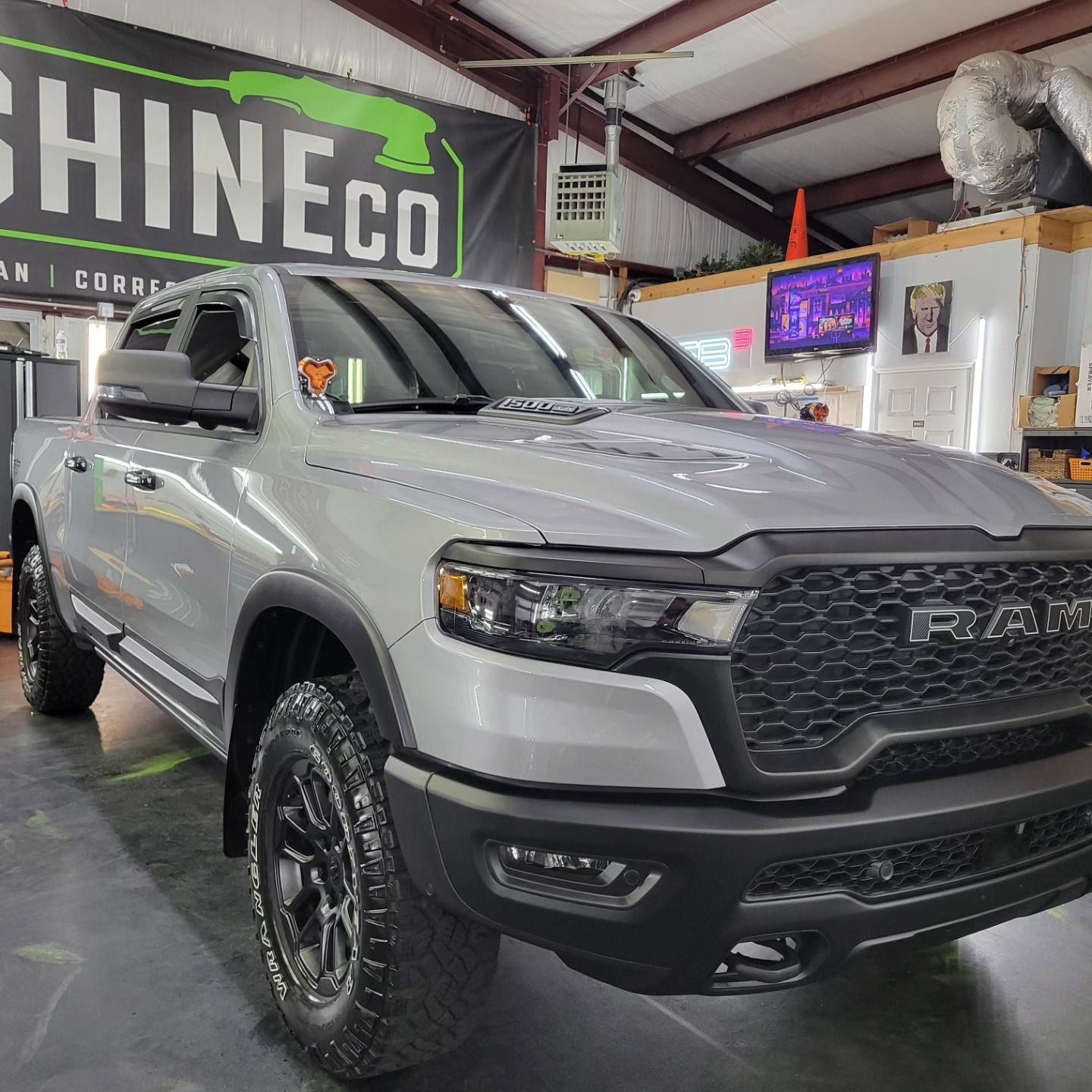 Gray Ram truck parked inside a shop with a ShineCo sign.
