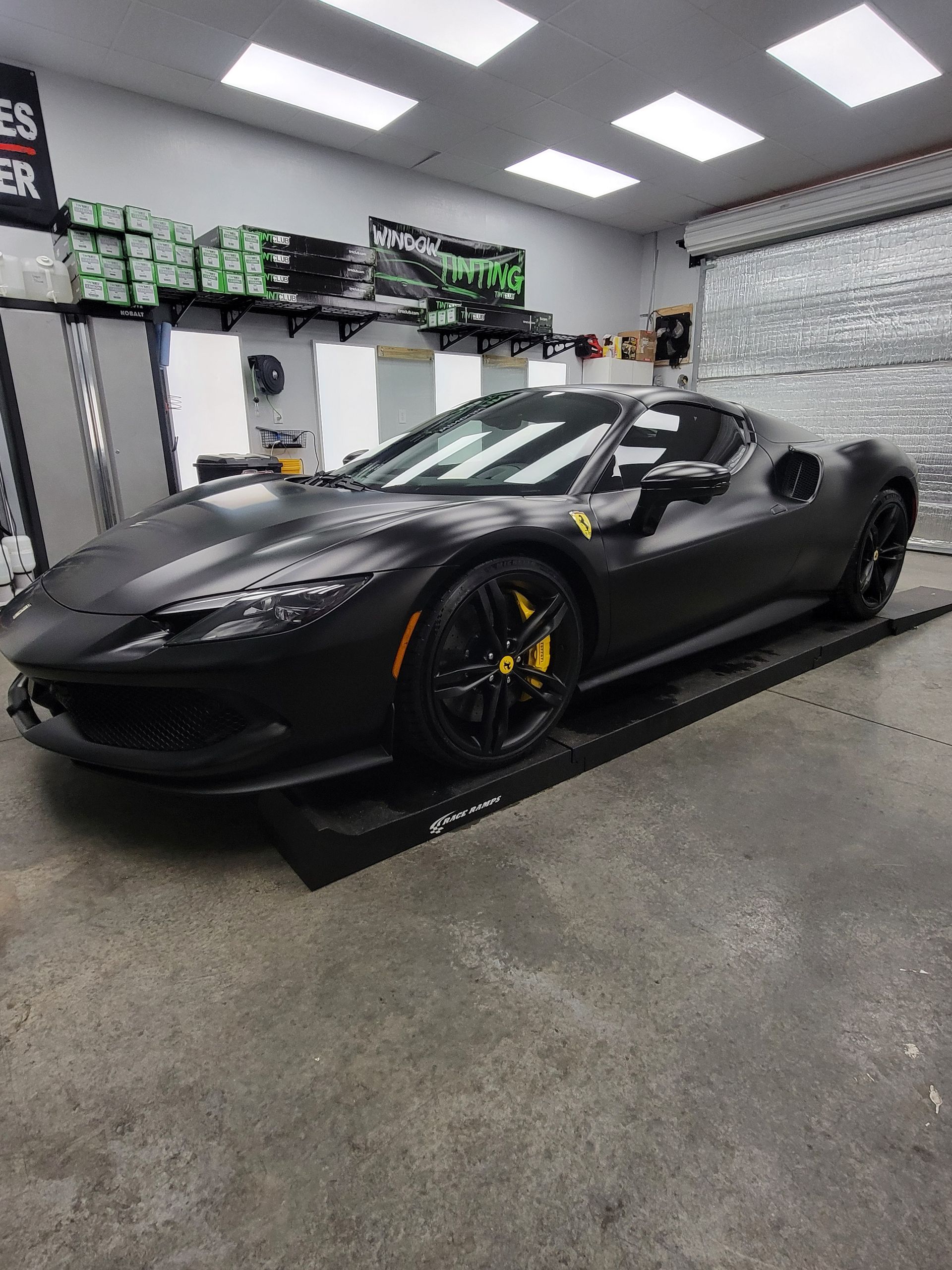 White BMW sedan, front view, shiny finish, in a shop.