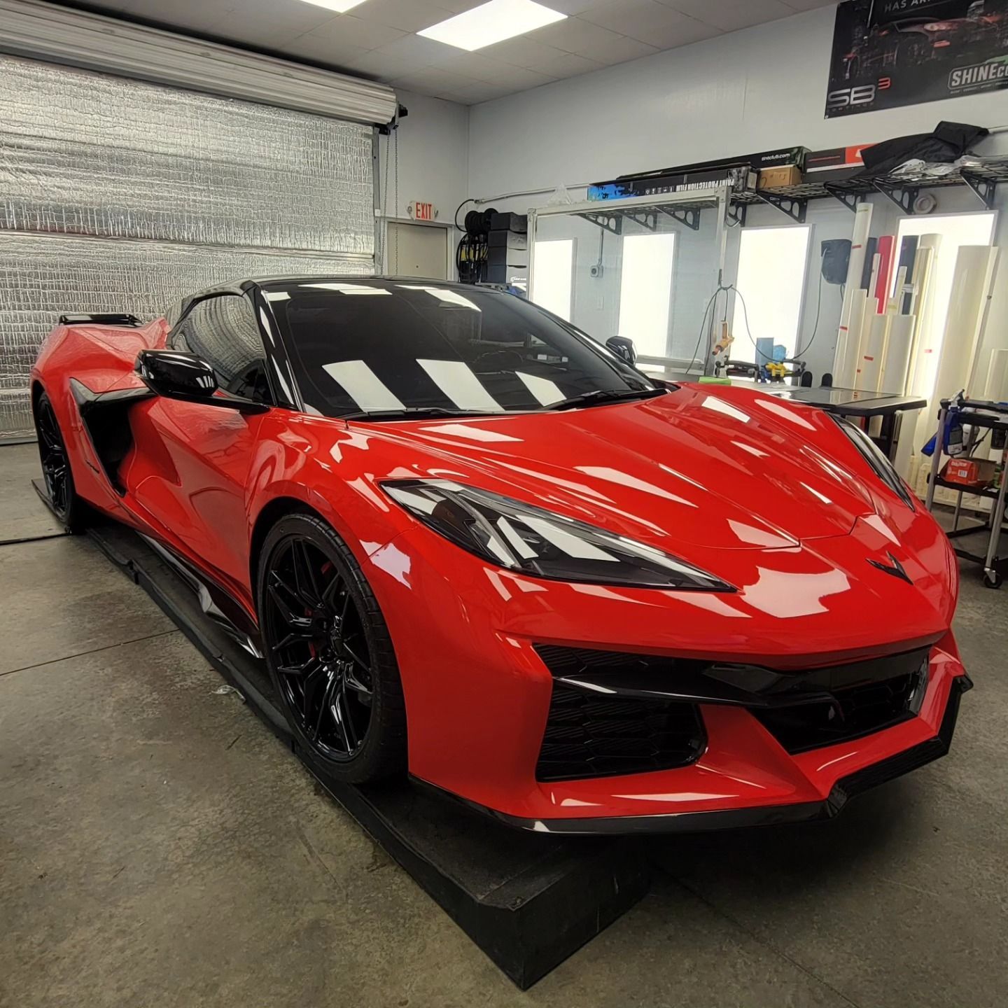 Red sports car in a garage, shown from the front-left on a turntable.