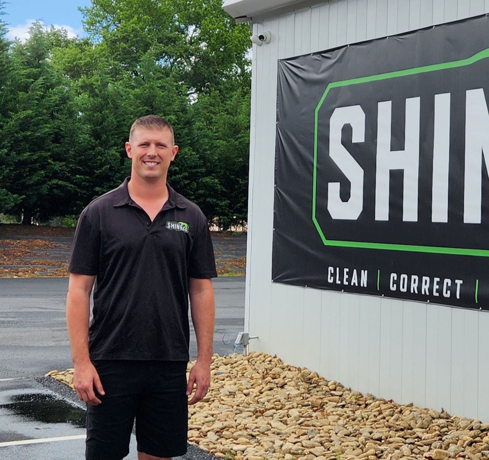 A man stands in front of a sign that says shin