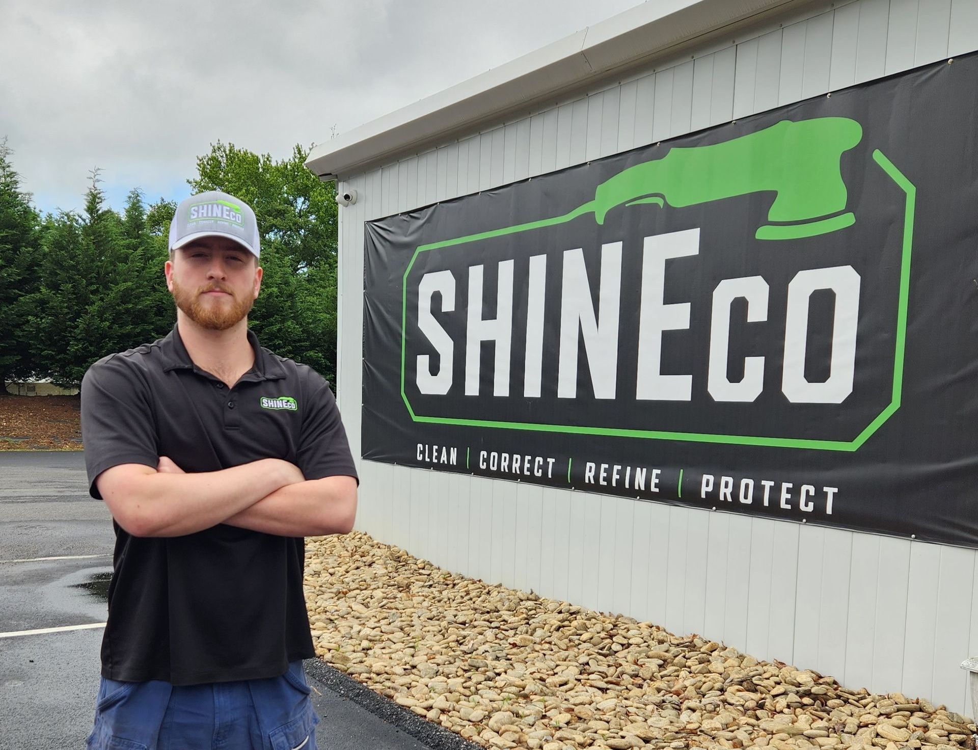 A man is standing in front of a sign that says shineco