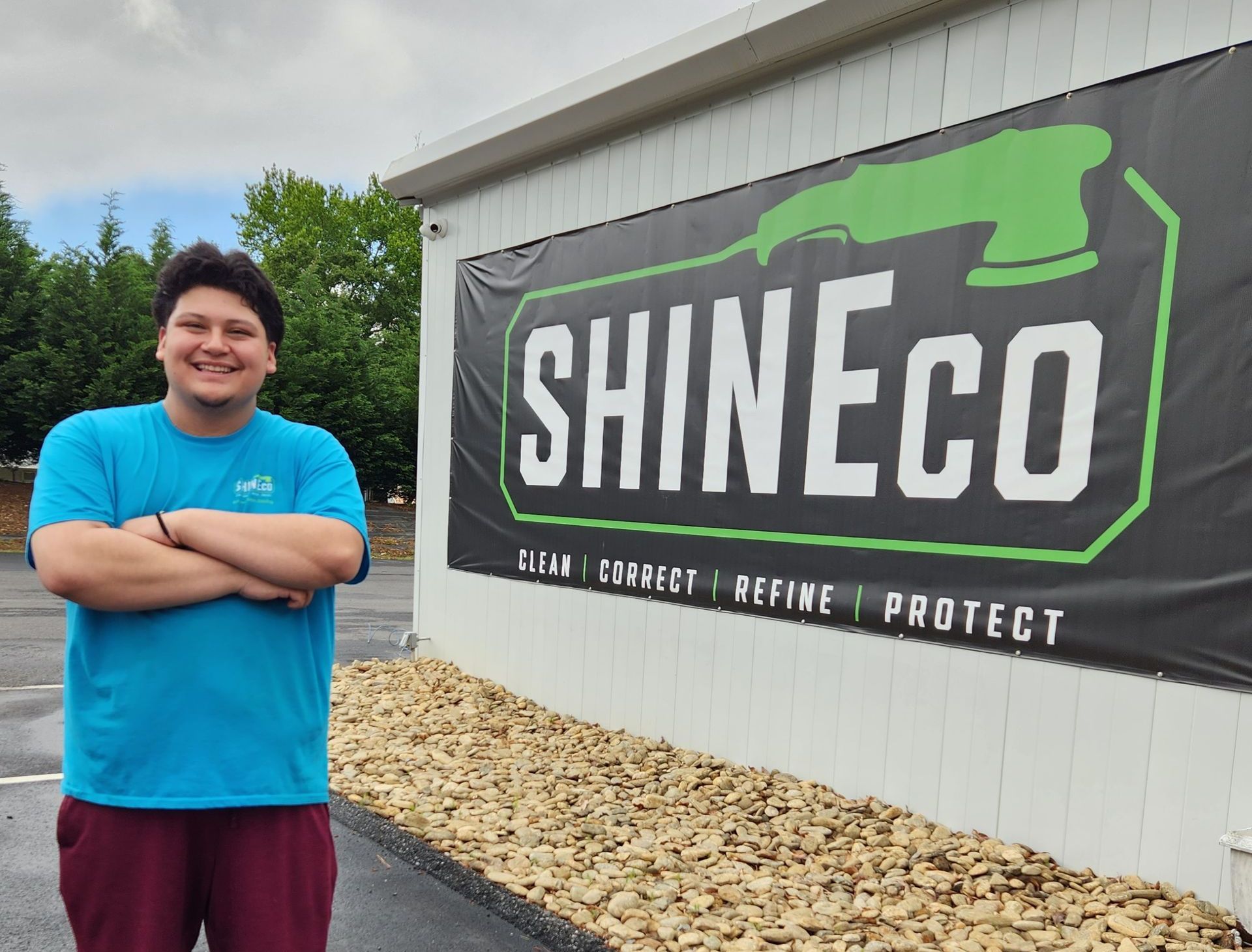A man is standing in front of a sign that says shineco
