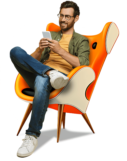 Un hombre está sentado en una silla naranja usando un teléfono celular.