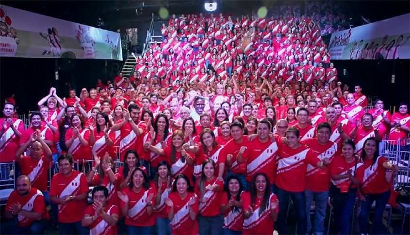 Un gran grupo de personas posa para una fotografía en un estadio.