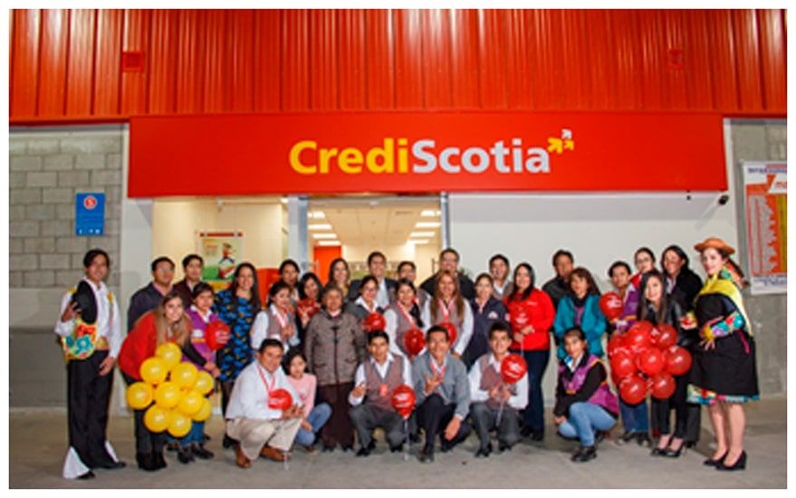 Un grupo de personas paradas frente a un edificio de CrediScotia.