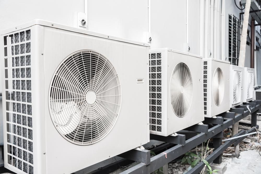 A Row of Air Conditioners Are Lined up Outside of A Building — JDG Refrigeration & Air in Goonellabah, NSW