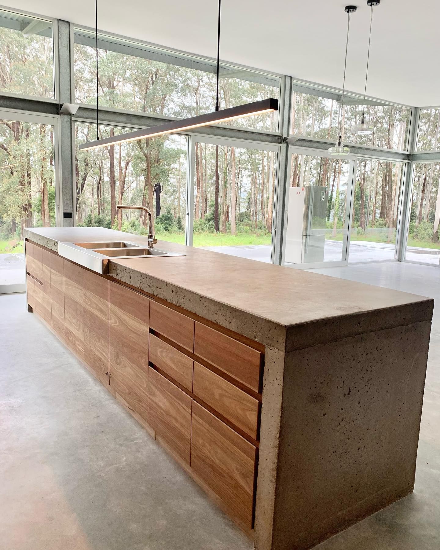 Kitchen With a Large Concrete Island, Wood Paneling, and Skylight — BSpoke Cabinet Making & Joinery in Unanderra, NSW